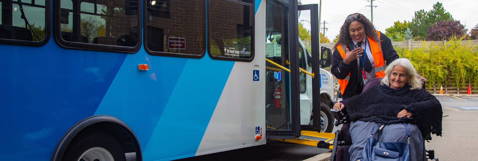 image of YRT driver assisting elderly woman in a mobility device and a man boarding a white vehicle